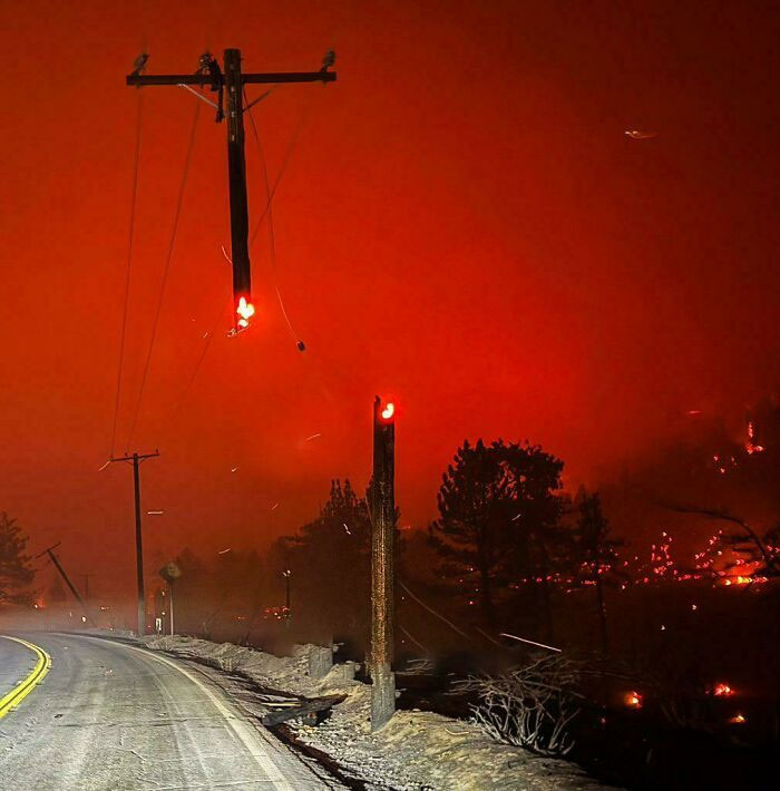 Power line on fire during a forest fire, creating a surreal scene. Power line on fire during a forest fire, creating a surreal scene.