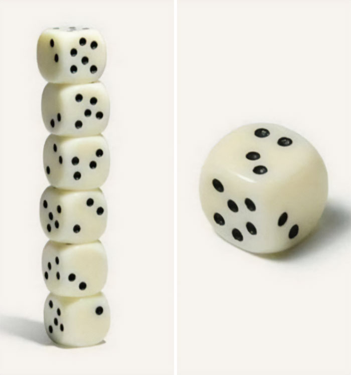 Stack of dice balanced unusually with one die separate, prompting curiosity. Stack of dice balanced unusually with one die separate, prompting curiosity.