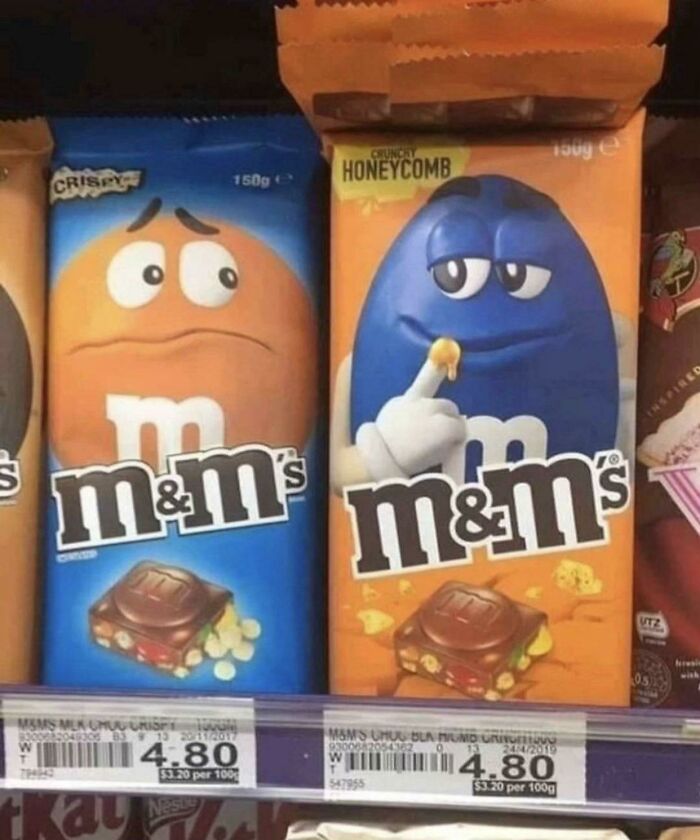 M&M's packages with expressive faces on a store shelf, one looking curious, the other puzzled. M&M's packages with expressive faces on a store shelf, one looking curious, the other puzzled.