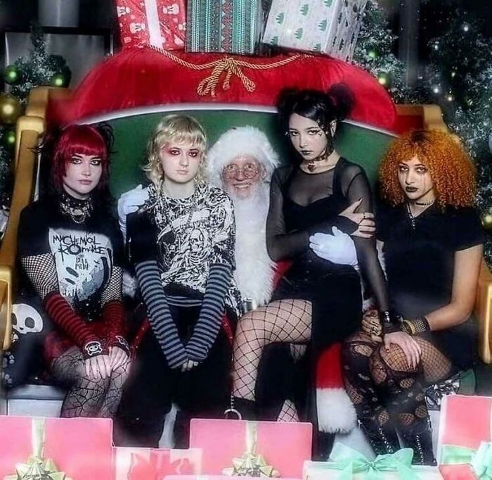 Santa with four goths on Christmas-themed chair surrounded by gifts, an unexpected 'Hmmm' moment. Santa with four goths on Christmas-themed chair surrounded by gifts, an unexpected 'Hmmm' moment.
