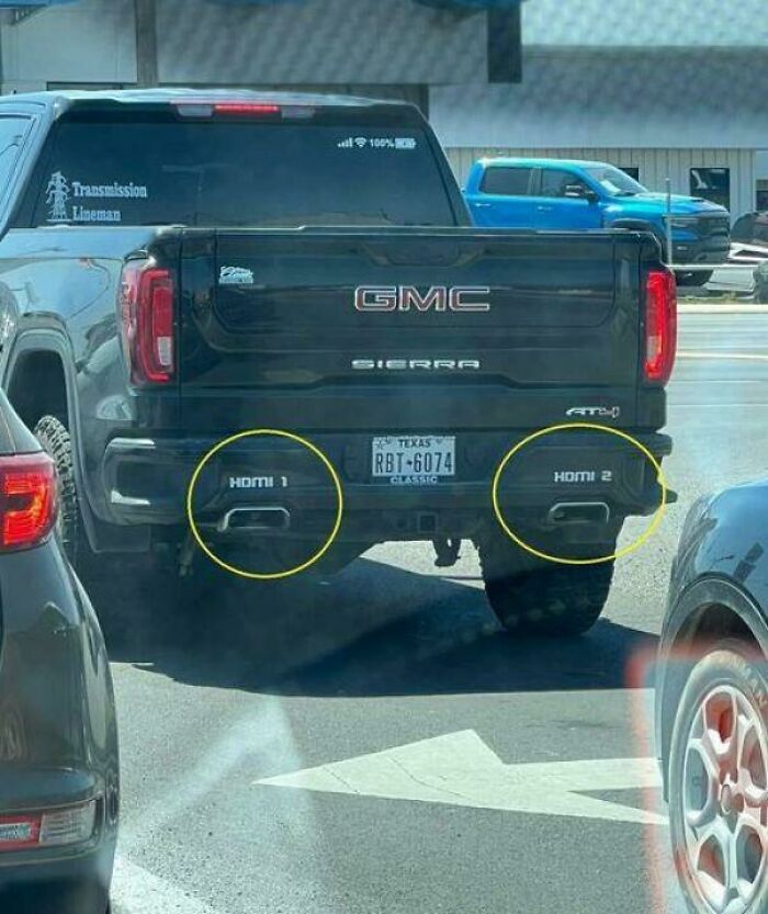 GMC Sierra with exhaust pipes labeled as HDMI 1 and HDMI 2, a humorous sight in traffic. GMC Sierra with exhaust pipes labeled as HDMI 1 and HDMI 2, a humorous sight in traffic.
