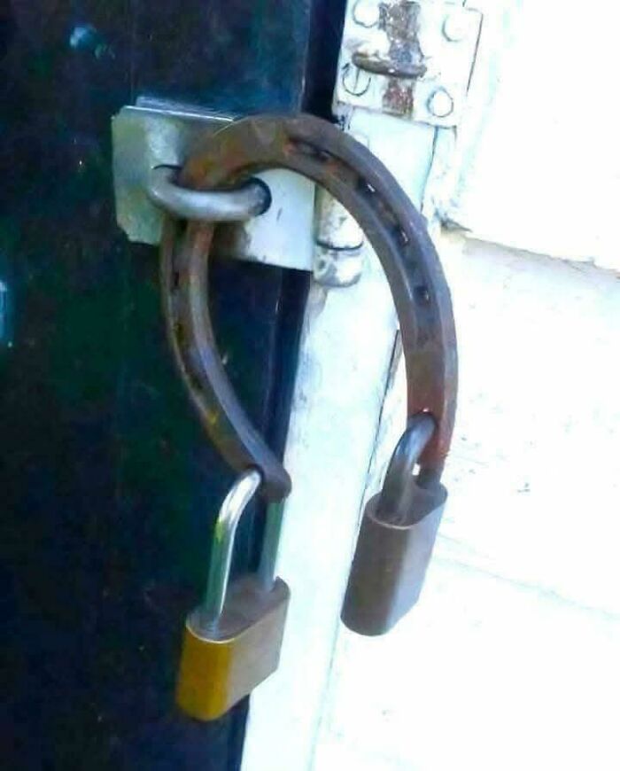 A door latch using a horseshoe secured with two padlocks, making it an unusual sight that made people go 'hmmm'. A door latch using a horseshoe secured with two padlocks, making it an unusual sight that made people go 'hmmm'.